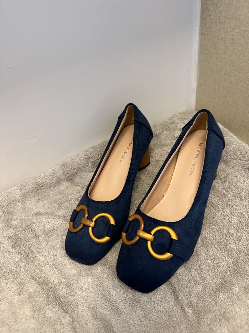 Blue Suede Chunky Heel Pumps Size 34 (Category: Heels) located in Santa Rosa. Submitted by alyssa21 (Listing ID 1465955042, Image 2). Description: - Style: Slip-on heels with a trendy square toe - Color & Material: Navy blue faux suede with wooden-look block heel - Details: Eye-catching gold metal horsebit buckles on the toes - Size: Marked Size 34 on the sole - Condition: Excellent, clean insoles and soles show virtually no wear.