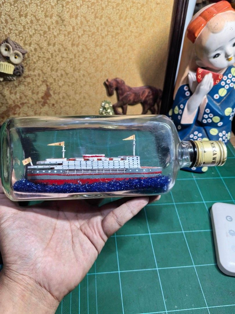 Bottle Ship - Nikka Whskey (Category: Other Home Decor) located in Cebu City. Submitted by dudes_villanueva (Listing ID 1466108729, Image 1). Description: Bottle Ship - Nikka Whskey 📌 Fecorative piece features a meticulously detailed white and red steamship model cradled inside a vintage Nikka whisky bottle over a sparkling bed of blue glitter water. 📌 In excellent condition. May kaunting scratch Lang on 1 side. 📌 Ship made of wood. Length : 9