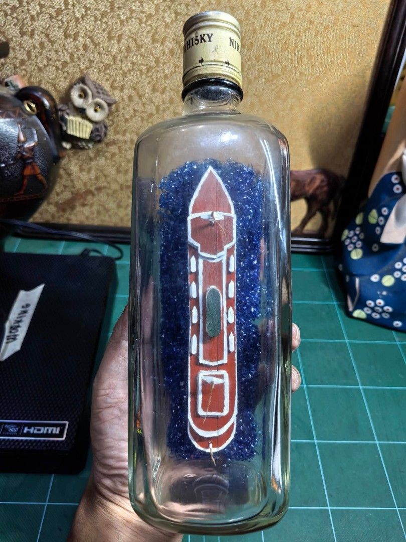 Bottle Ship - Nikka Whskey (Category: Other Home Decor) located in Cebu City. Submitted by dudes_villanueva (Listing ID 1466108729, Image 3). Description: Bottle Ship - Nikka Whskey 📌 Fecorative piece features a meticulously detailed white and red steamship model cradled inside a vintage Nikka whisky bottle over a sparkling bed of blue glitter water. 📌 In excellent condition. May kaunting scratch Lang on 1 side. 📌 Ship made of wood. Length : 9
