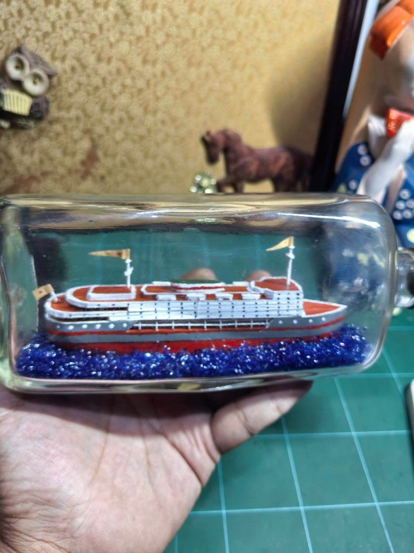 Bottle Ship - Nikka Whskey (Category: Other Home Decor) located in Cebu City. Submitted by dudes_villanueva (Listing ID 1466108729, Image 2). Description: Bottle Ship - Nikka Whskey 📌 Fecorative piece features a meticulously detailed white and red steamship model cradled inside a vintage Nikka whisky bottle over a sparkling bed of blue glitter water. 📌 In excellent condition. May kaunting scratch Lang on 1 side. 📌 Ship made of wood. Length : 9