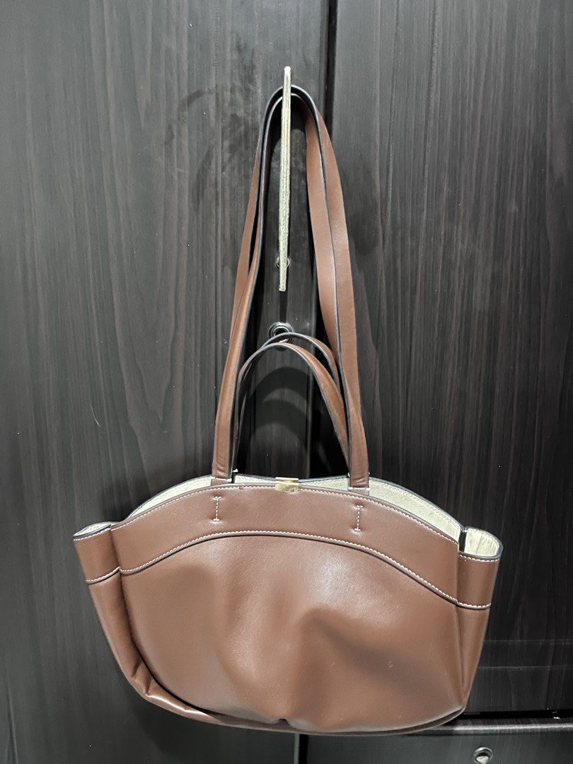 Brown Leather Shoulder Bag Tote (Category: Shoulder Bags) located in Tarlac. Submitted by kylapam15 (Listing ID 1466041306, Image 1). Description: - Material: Brown leather with stylish white contrast stitching - Straps: Dual strap drop lengths for versatile carrying - Storage: Medium capacity daily bag with convenient side pockets on both ends - Design: Structured base with soft sides and clean interior lining - Condition: Excellent, ready for d