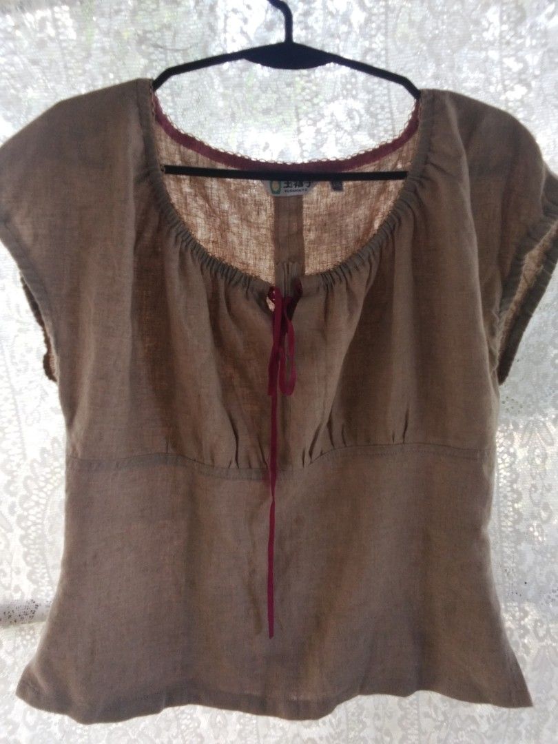 Brown Linen Blouse with Red Ribbon (Category: Blouses) located in Alaminos. Submitted by dangpreloved01 (Listing ID 1465965929, Image 1). Description: - Color: Brown - Material: Lightweight textured linen - Design: Gathered neckline with a deep red ribbon tie - Sleeves: Short sleeves - Closure: Hook-and-eye near the neckline - Condition: Great casual top for warm weather.