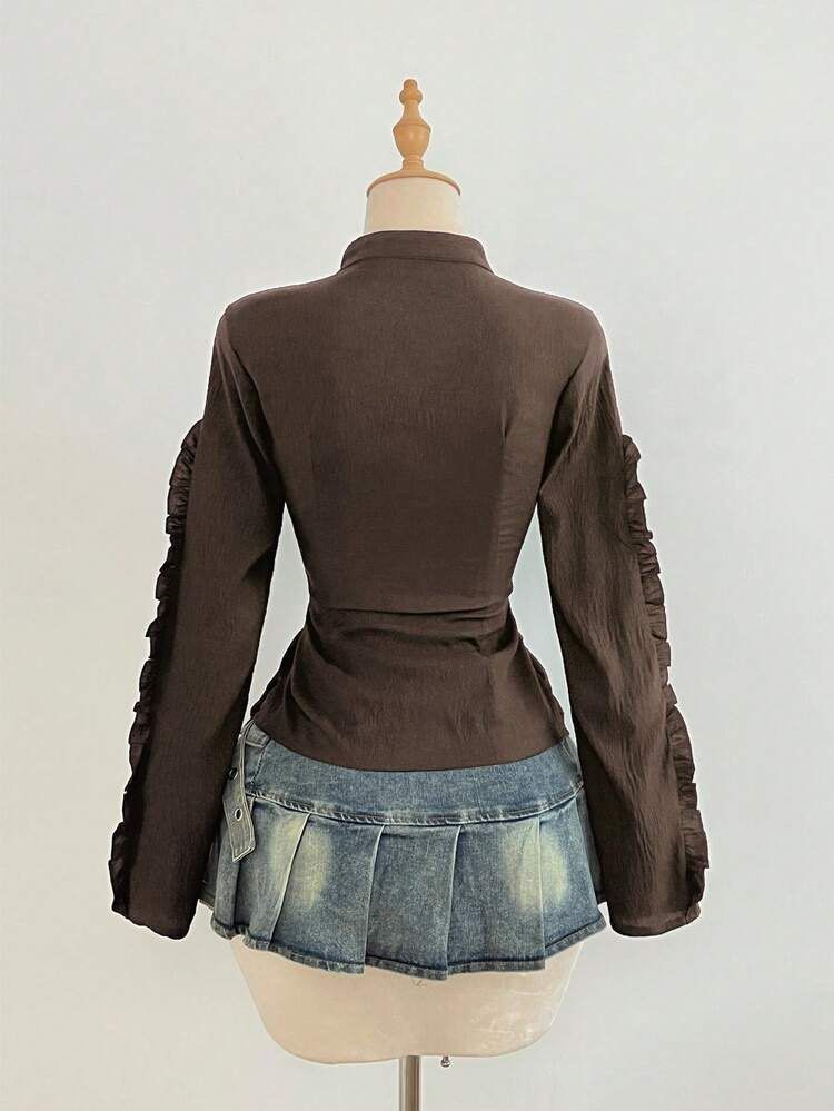 Brown Y2K Ruffled Zip-Up Blouse Top Size S (Category: Blouses) located in Quezon City. Submitted by getitrightaway.ph (Listing ID 1466068154, Image 2). Description: - Size: S - Color: Dark brown - Style: Fitted long-sleeve blouse with vertical ruching - Details: Satin ribbon trim, front zipper closure, ruffled outer sleeves - Fabric: Lightweight and textured.