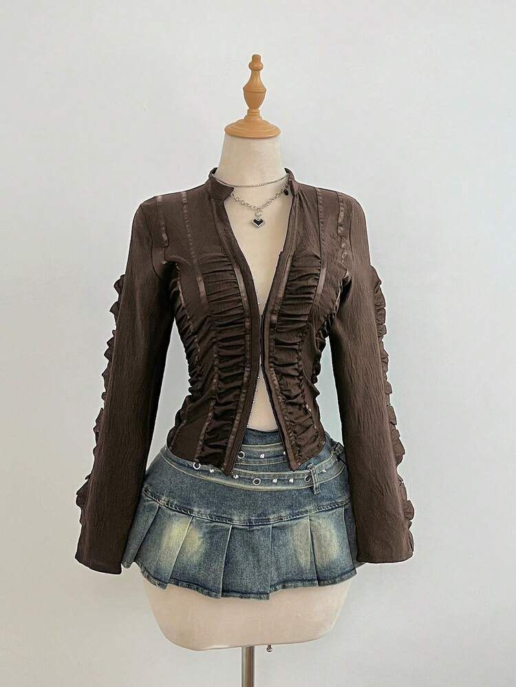 Brown Y2K Ruffled Zip-Up Blouse Top Size S (Category: Blouses) located in Quezon City. Submitted by getitrightaway.ph (Listing ID 1466068154, Image 1). Description: - Size: S - Color: Dark brown - Style: Fitted long-sleeve blouse with vertical ruching - Details: Satin ribbon trim, front zipper closure, ruffled outer sleeves - Fabric: Lightweight and textured.