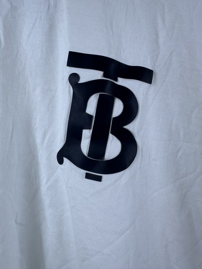 Burberry Monogram TB Logo White T-Shirt (Category: Shirts) located in Manila. Submitted by declutterpromax (Listing ID 1466014884, Image 2). Description: - Burberry TB Monogram T-Shirt - Color: Crisp White with Black Rubber TB Logo Patch - Material: Premium 100% Cotton (Made in Portugal) - Fit: Classic crew neck, short sleeves, regular fit - Details: Includes interior Burberry London England collar tag - Condition: Brand new / Excellent daily cas