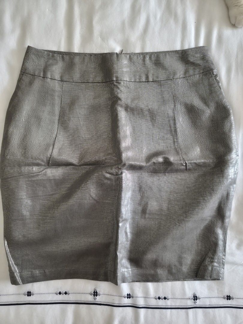 Camaïeu Metallic Grey Mini Skirt (Category: Skirts) located in Quezon City. Submitted by corrnic (Listing ID 1466019890, Image 2). Description: - Brand: Camaïeu - Color: Metallic grey with a shiny, light-catching finish - Style: Mini skirt with structured panel details and a subtle hem slit - Fit: Mid-waist, measures approx. 15.5 inches across the waistband - Closure: Back zipper - Origin: Made in China - Occasion: Ideal for going out, parties, a