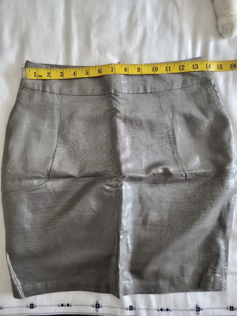 Camaïeu Metallic Grey Mini Skirt (Category: Skirts) located in Quezon City. Submitted by corrnic (Listing ID 1466019890, Image 3). Description: - Brand: Camaïeu - Color: Metallic grey with a shiny, light-catching finish - Style: Mini skirt with structured panel details and a subtle hem slit - Fit: Mid-waist, measures approx. 15.5 inches across the waistband - Closure: Back zipper - Origin: Made in China - Occasion: Ideal for going out, parties, a