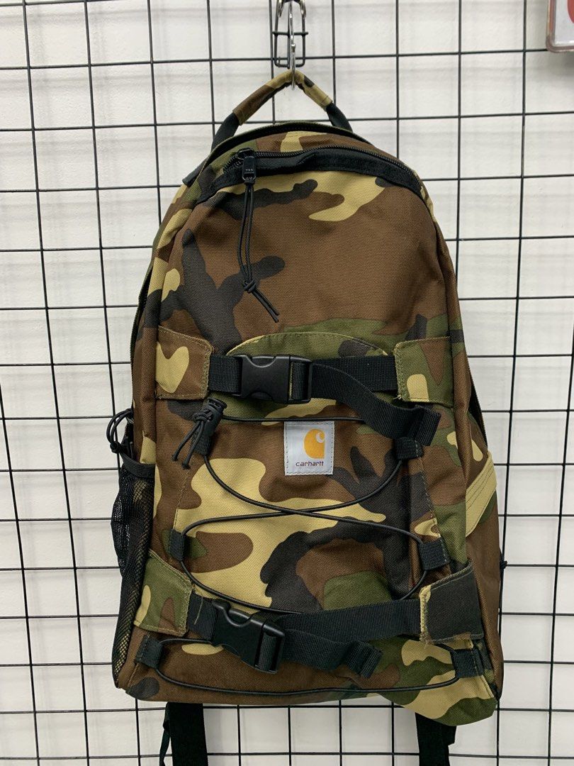 Carhartt Camouflage Backpack with Bungee Cords (Category: Backpacks) located in Cavite. Submitted by jeromeaba95864 (Listing ID 1466108579, Image 3). Description: - Brand: Carhartt - Pattern: Classic woodland camo - Material: Heavy-duty canvas built for durability - Storage: Spacious main compartment for daily carry, school, or travel - Exterior: Front dual buckle straps, elastic bungee cords, and dual mesh side pockets - Hardware: Smooth YKK zip