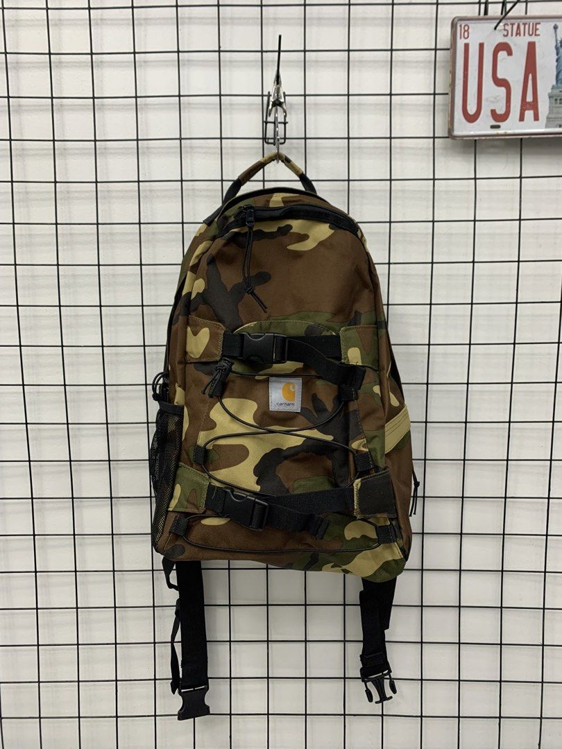 Carhartt Camouflage Backpack with Bungee Cords (Category: Backpacks) located in Cavite. Submitted by jeromeaba95864 (Listing ID 1466108579, Image 1). Description: - Brand: Carhartt - Pattern: Classic woodland camo - Material: Heavy-duty canvas built for durability - Storage: Spacious main compartment for daily carry, school, or travel - Exterior: Front dual buckle straps, elastic bungee cords, and dual mesh side pockets - Hardware: Smooth YKK zip