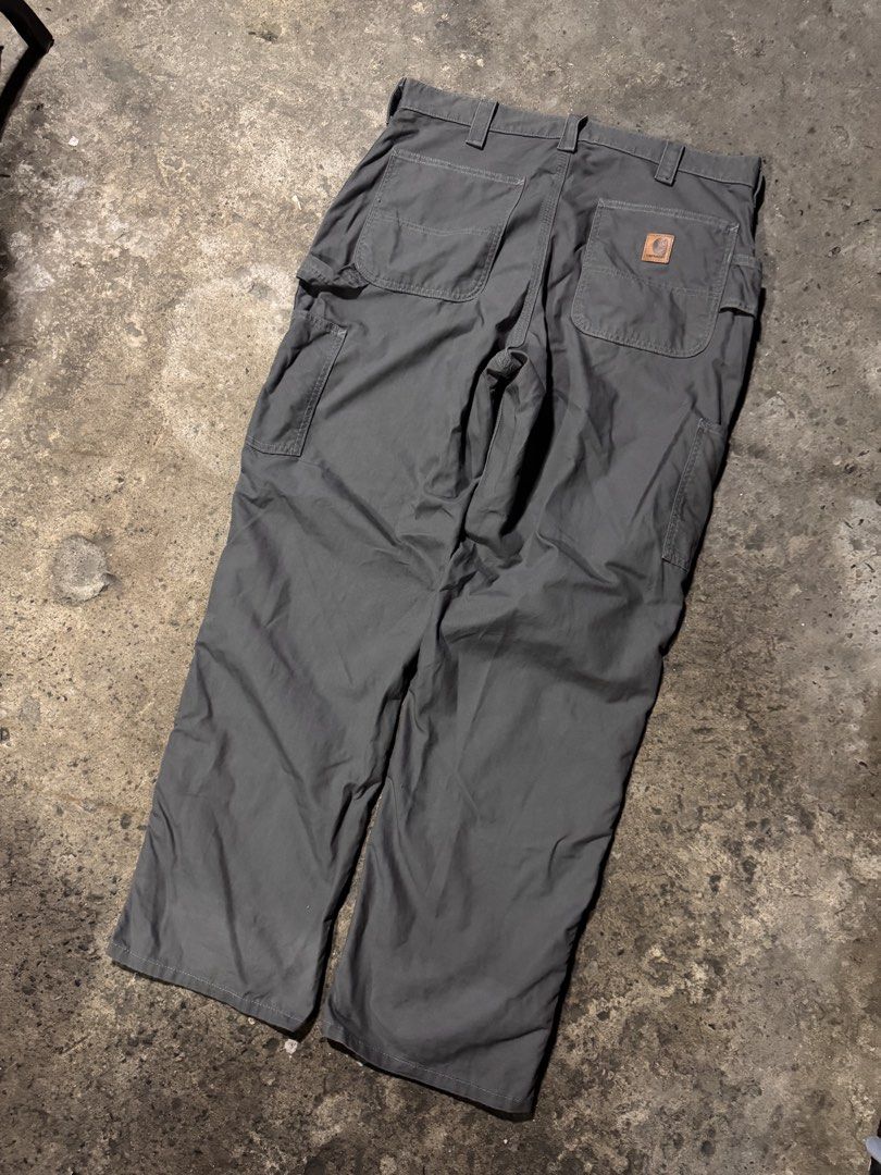 Carhartt Work Pants Grey Cargo Utility Trousers (Category: Jeans) located in Pasig City. Submitted by dripthrift1600 (Listing ID 1466101356, Image 2). Description: - Authentic Carhartt utility work pants in versatile charcoal grey - Built tough with heavy-duty, durable cotton canvas material - Features multiple side tool pockets, a left-leg hammer loop, and reinforced back pockets - Designed with a classic straight leg fit and extra-durable tripl