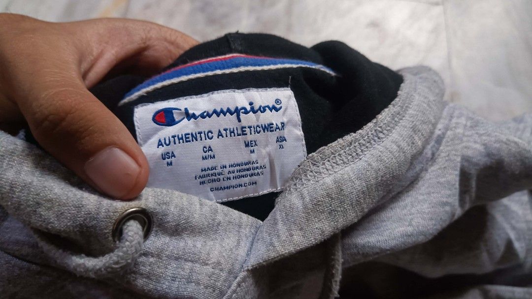 Champion hoodie (Category: Hoodies) located in Manila. Submitted by boot_tdm (Listing ID 1466154073, Image 2). Description: - Authentic grey Champion hoodie with contrast black hood lining - Size: US Medium / Asia XL - Classic embroidered logo on chest and iconic patch on left sleeve - Practical front kangaroo pocket with adjustable drawstring - Material: 50% cotton, 50% polyester blend for durability and comfort - Condition: Excellent, made in H