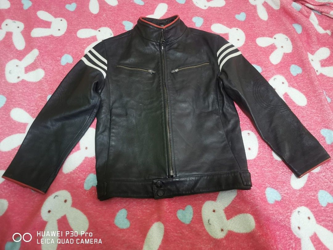 Chickeeduck Leather Jacket, 9 to 10 years old (Category: Coats, Jackets and Outerwear) located in Makati City. Submitted by relianzmae57131 (Listing ID 1466032931, Image 1). Description: - Material: black leather (built to last) - Design: Classic 3 white stripes on shoulders - Accents: Eye-catching red trim on high collar and cuffs - Pockets: Front zipper closure with 2 zipped chest pockets - Fit/Cuffs: Adjustable bottom hem snaps and wrist zippe