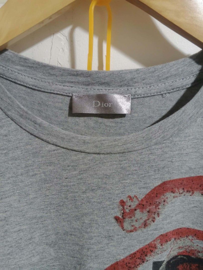 Christian Dior Grey Graphic Tee (Category: Tshirts & Polo Shirts ) located in Kabankalan. Submitted by hiddenjunk_ph (Listing ID 1466104186, Image 3). Description: - Brand: Made in Italy - Size: S - Material: 100% cotton - Color: Grey with red and black front graphic print - Design: Crew neck, short sleeves - Condition: Clean, vibrant colors with intact tags.