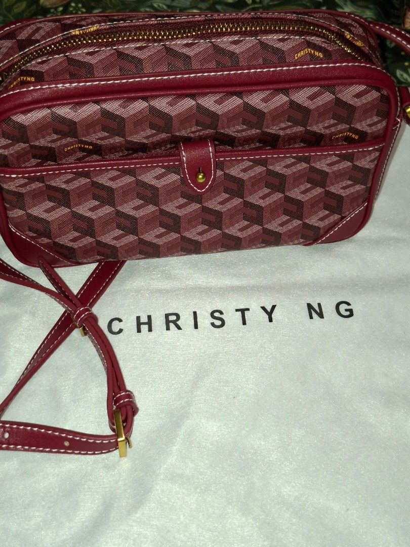 Christy Ng Red Monogram Crossbody Bag (Category: Luxury Bags & Wallets) located in Manila. Submitted by mialiurshop (Listing ID 1465990495, Image 1). Description: - Brand: Christy Ng - Style: Crossbody bag with all-over geometric cube monogram pattern - Color: Red with gold-tone hardware - Closure: Secure zip closure and front flap pocket with button closure - Strap: Adjustable matching shoulder strap - Interior: Clean burgundy fabric lining with