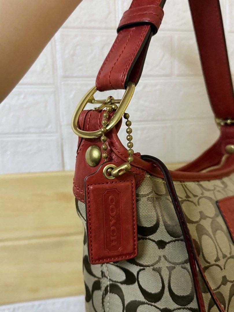 Coach Bucket NEW CONDITION (Category: Luxury Bags & Wallets) located in Manila. Submitted by angelcurated (Listing ID 1465974521, Image 2). Description: - Brand: Coach - Material: Signature C jacquard fabric with red leather trim and base corners - Hardware: Gold-tone - Exterior: Front slip pocket and classic embossed hangtag - Strap: Adjustable red leather shoulder strap - Interior: Spacious with sturdy stitching - Condition: Great everyday bag 