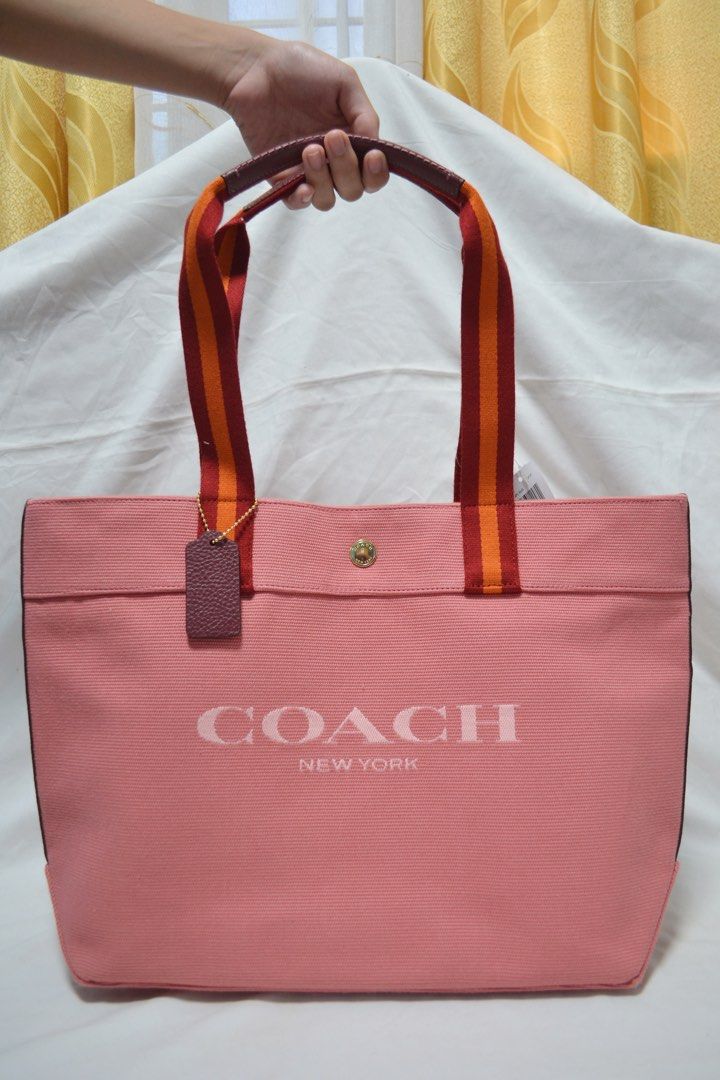 COACH Canvas Tote in Gold/Taffy Multi (Category: Luxury Bags & Wallets) located in Baras. Submitted by btsdrafts (Listing ID 1465961356, Image 1). Description: - Brand new and original - Material: Canvas and Refined Pebble Leather - Fabric lining - Gold-tone hardware - Snap closure - Interior: Zip pocket, cellphone and multifunction pockets - Handles with 10in drop - Approximate measurements: 13in (L) x 11¾in (H) x 6in (W) - Inclusions: Care card
