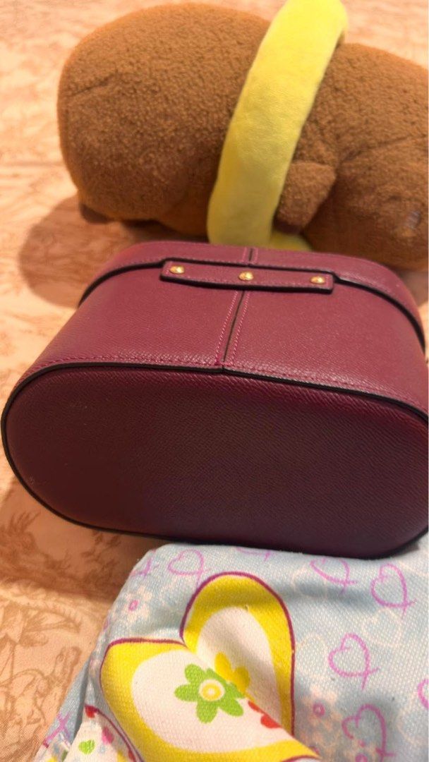 Coach Maroon Vanity Case Bag (Category: Luxury Bags & Wallets) located in Davao. Submitted by triftedbagsforyou (Listing ID 1466052313, Image 2). Description: - Brand: Coach - Color: Rich maroon - Material: Textured leather with gold-tone hardware - Closure: Eye-catching rhinestone twist-lock on front flap - Interior: Clean soft tan lining with an open wall pocket - Details: Single top handle and gold Coach horse and carriage logo stamp - Conditi