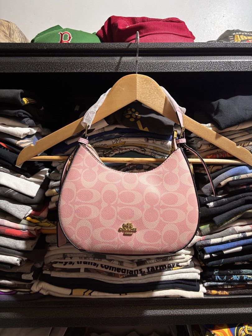 Coach Pink Signature Shoulder Bag (Category: Luxury Bags & Wallets) located in General Santos City (Dadiangas). Submitted by andrei_ciocon (Listing ID 1466093488, Image 1). Description: - Brand new, never used Coach shoulder bag - Pink signature monogram pattern with gold-tone hardware - Adjustable strap with original protective wrapping intact - Structured design with secure zip closure - Includes a special Coach gift box decorated with fun lip 