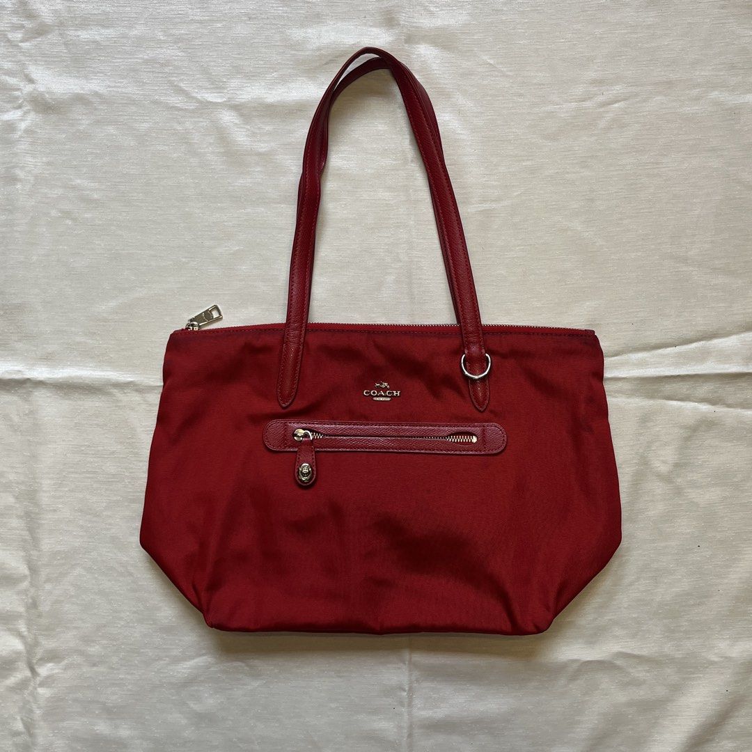 Coach Sawyer Red Nylon Tote Bag (Category: Tote Bags) located in Dasmarinas. Submitted by minx203 (Listing ID 1466101157, Image 1). Description: - Brand: Coach - Material: Durable bright red nylon with leather straps and trim - Closure: Secure top zip closure - Exterior: Front zippered pocket with twist-lock accent - Interior: Spacious red-lined fabric with an extra zip pocket and slip pockets - Condition: Shows minor discoloration near the top z