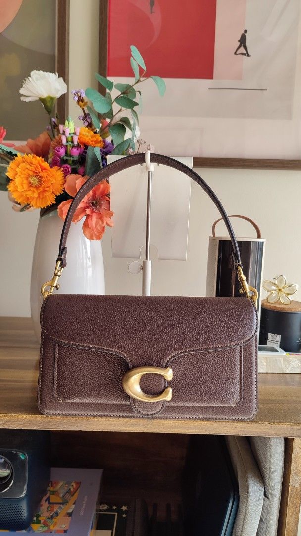 Coach Tabby Shoulder Bag Brown Leather (Category: Luxury Bags & Wallets) located in Manila. Submitted by trishcaj (Listing ID 1465959185, Image 1). Description: - Authentic Coach tabby 26 shoulder bag in dark brown pebbled leather - Antique brass Signature C hardware on the front flap - Structured accordion-style design with 3 internal compartments and a zippered pocket - Clean interior lining featuring the embossed gold logo stamp - Versatile st