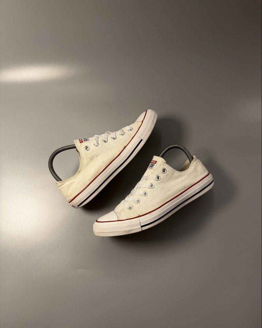 Converse All Star Low Top White Sneakers (Category: Sneakers) located in Caloocan City. Submitted by maempenafi21452 (Listing ID 1466068770, Image 1). Description: - Brand: Converse - Style: Classic low top sneakers - Color: White canvas with red and blue midsole stripes - Soles: Brown rubber with standard diamond tread - Size: US Men's 7.5 / Women's 9.5 / EUR 41 - Condition: Clean interior with minor wear and smudges on the canvas upper.