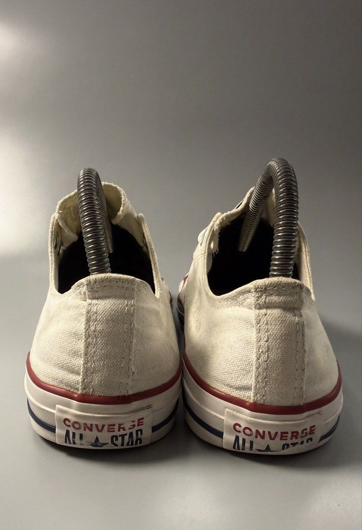 Converse All Star Low Top White Sneakers (Category: Sneakers) located in Caloocan City. Submitted by maempenafi21452 (Listing ID 1466068770, Image 3). Description: - Brand: Converse - Style: Classic low top sneakers - Color: White canvas with red and blue midsole stripes - Soles: Brown rubber with standard diamond tread - Size: US Men's 7.5 / Women's 9.5 / EUR 41 - Condition: Clean interior with minor wear and smudges on the canvas upper.