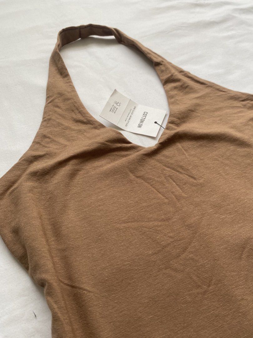 Cotton On Brown Halter Top (Category: Sleeveless) located in Valenzuela. Submitted by mandies_25 (Listing ID 1466084206, Image 2). Description: - Brand: Cotton On - Style: Brown halter top with V-neckline - Condition: Brand new with tags attached - Material: Soft and stretchy fabric - Features: Simple, versatile, and great for layering or solo wear.