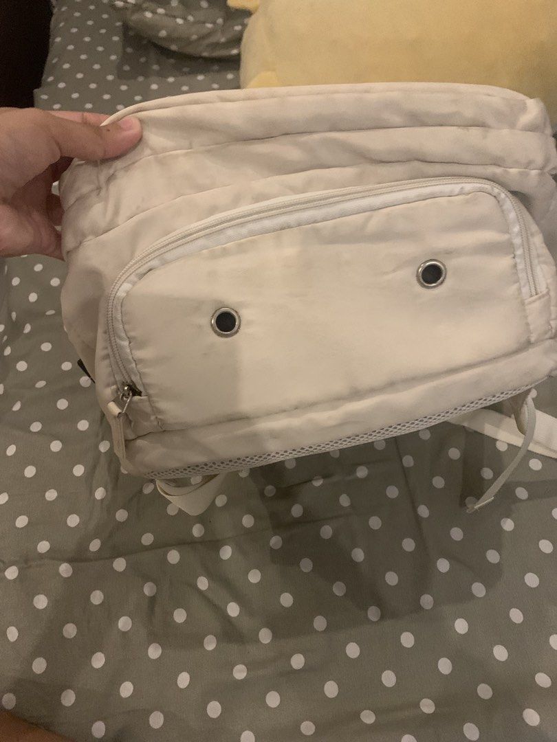 Cream beige multi-pocket travel backpack (Category: Backpacks) located in Manila. Submitted by pureforest_68db5f (Listing ID 1466074251, Image 3). Description: - Color: Cream beige with stylish front metal grommets - Storage: Multiple zippered compartments and convenient side pockets - Interior: Black lining with a mesh pocket divider - Comfort: Adjustable shoulder straps with breathable mesh backing - Condition: Shows visible scuff marks and dir