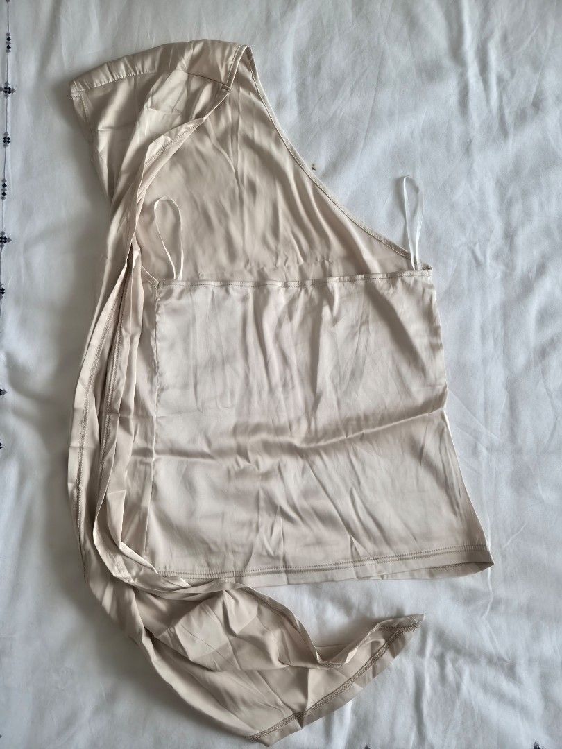 Cream One-Shoulder Draped Top with Long Sashes (Category: Sleeveless) located in Quezon City. Submitted by corrnic (Listing ID 1466039424, Image 3). Description: - Color: Cream - Style: Chic one-shoulder top with flowing sashes - Material: Soft and stretchy fabric - Details: Gathered bodice, asymmetrical look - Condition: Great, worn only a few times - Styling: Easily pairs with shorts or trousers.