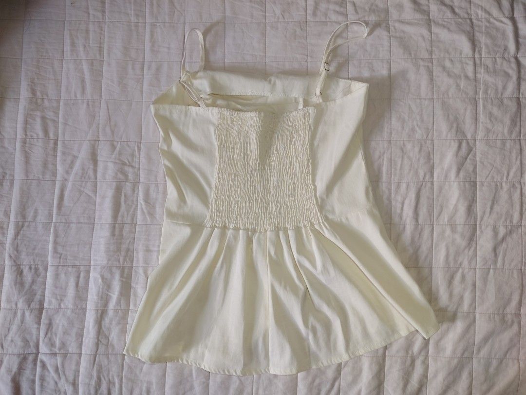 Cream Pleated Bust Top with Side Slit (Category: Sleeveless) located in Tarlac. Submitted by your_finds (Listing ID 1466011308, Image 2). Description: Description: - S-M ang size - Color cream - Smocked sa likod - Adjustable ang straps - Side Slit Condition: 10/10 / Excellent condition Medida size (inch) Bust: 33-35 Length: 18.5.