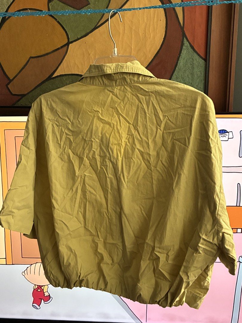 Cropped Khaki Button-Up Shirt XL (Category: Blouses) located in Pasig City. Submitted by alvinthedecluttererist (Listing ID 1466020490, Image 3). Description: - Brand: Lalu - Color: Light Yellow, Khaki -Width: 44cm, Length: 53cm - Size: XL / UK 14 - Fit: Relaxed and lightweight - Features: Short sleeves with folded cuff, collared neckline, front button closure, and elastic gathered hem - Condition: Great for casual warm-weather wear.