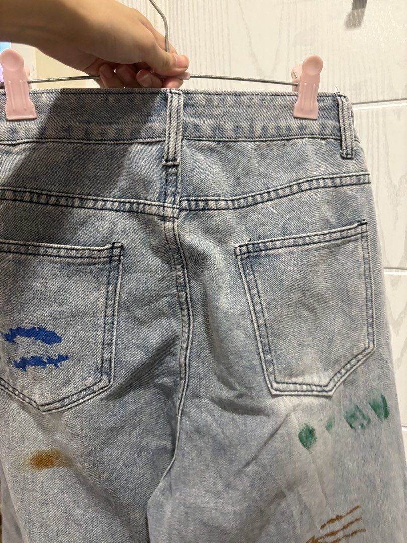 Custom Painted Ripped Jeans Size 27-28 (Category: Jeans) located in Mandaluyong City. Submitted by shopwithjuu (Listing ID 1466053011, Image 3). Description: Size 27-28 Light wash mid-rise denim jeans featuring custom paint splatters and distressed knee rips. A fun streetwear staple with colorful accents on the front and back. Button and zipper closure..