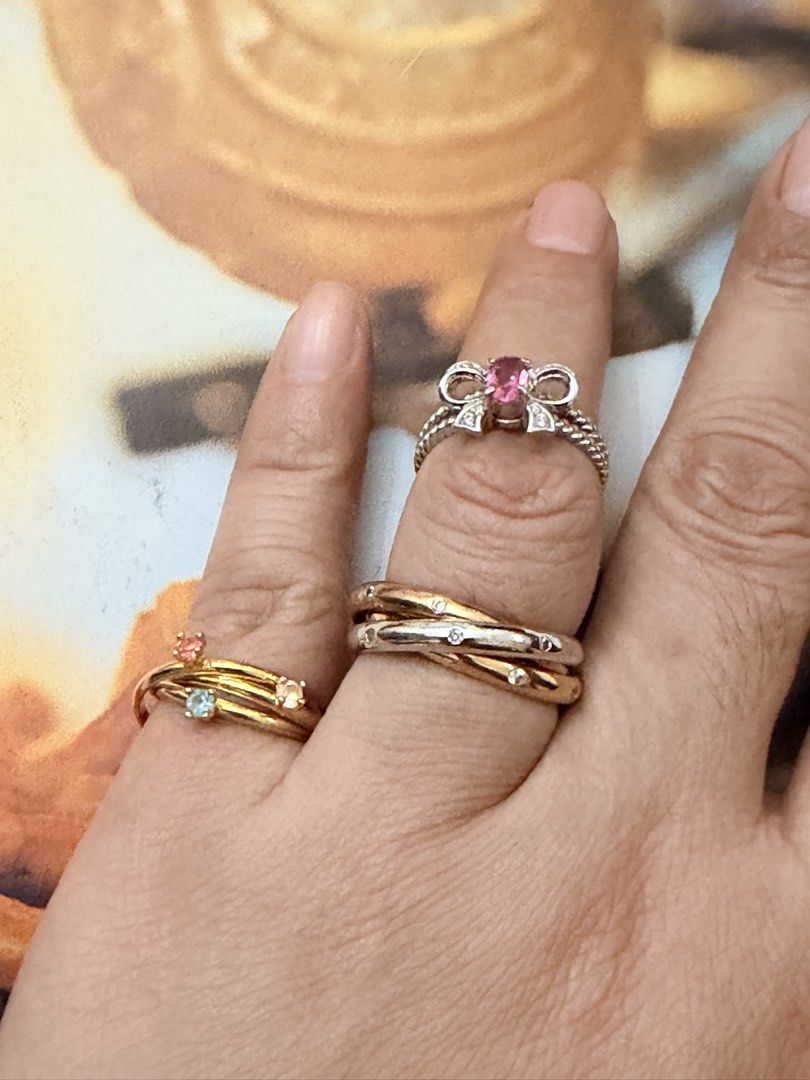 Cute Japan rings.💍 (Category: Rings) located in Pasig City. Submitted by smartshopping.ph (Listing ID 1466076408, Image 2). Description: Cute rings.💍 Top Left Ring: A bow with brilliant oval-cut pink rhinestone at its center. Size 6 350 php • Bottom Left Ring: A modern multi-layer gold stackable ring set joined dynamically with tiny charm hooks, detailed with miniature prong-set crystal settings. Size 6.5. 500 php • Right Interlocking Bands: A 