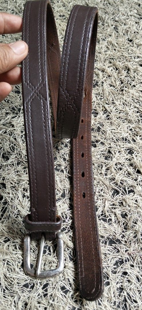 Dark brown PURE SOLID GENUINE leather belt with silver tone buckle (Category: Belts) located in Paranaque City. Submitted by michael-08 (Listing ID 1466038640, Image 2). Description: - Color: Dark brown with a textured finish - Material: Genuine leather strap with silver-tone metal buckle - Details: Stylish double row stitching - Fit: Multiple sizing holes for an adjustable fit - Style: Classic casual design, ideal for everyday wear PURE SOLID GE