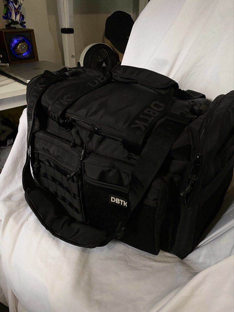 DBTK Black Duffle Bag (Category: Sling Bags) located in Quezon City. Submitted by godspeed___ (Listing ID 1466141616, Image 1). Description: - Brand: DBTK (Don't Blame The Kids) - Color: Black - Durable heavy-duty straps and rugged zippers - Multiple external compartments and mesh pockets - Tactical-style webbing loops on the front pocket - Includes a matching drawstring pouch with logo patch - Versatile use: ideal for everyday carry or the gym D