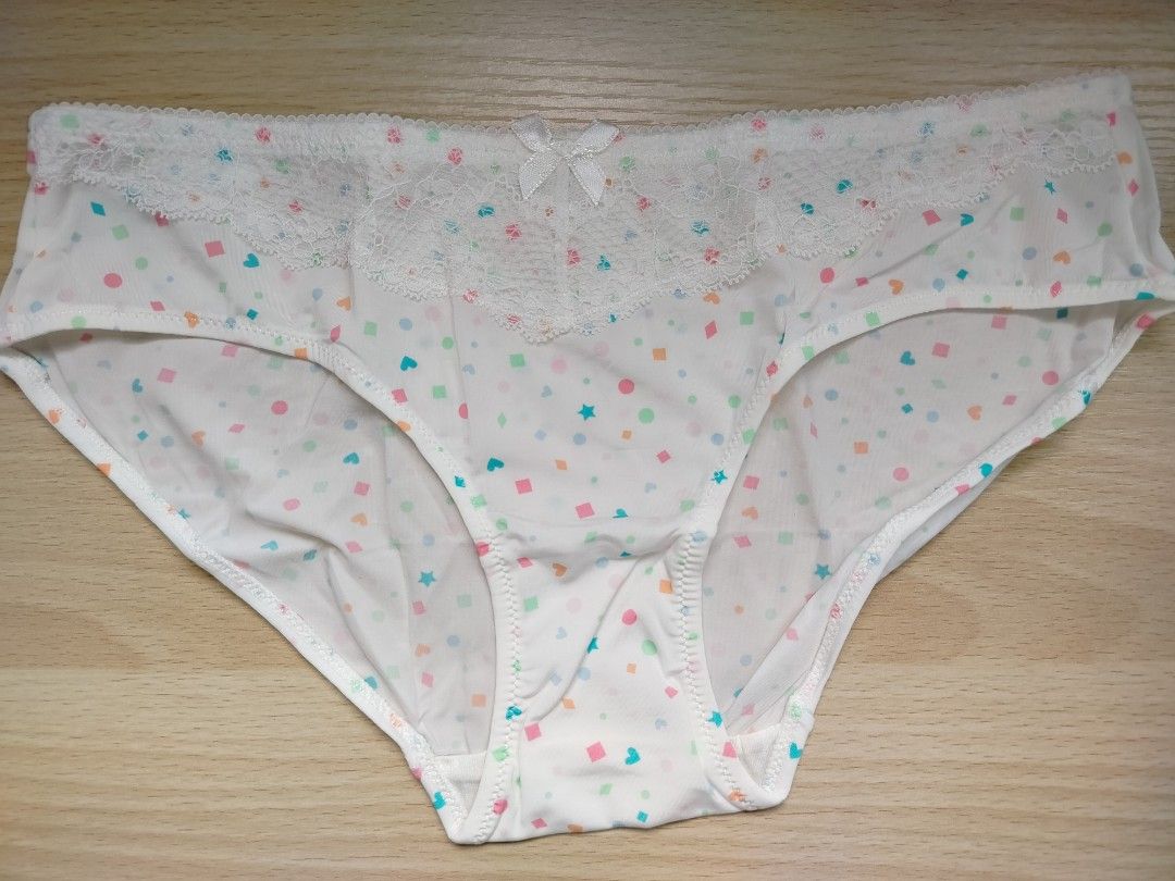 DEAN-FUN White Patterned Panties with Lace Detail (Category: Undergarments & Loungewear) located in Rizal. Submitted by etcthings (Listing ID 1466153589, Image 2). Description: White panties with colorful geometric shapes like hearts, stars, squares, and circles printed all over. Soft white lace panel across the top band. Small white bow centered at the front waistband. Smooth fabric with clean white stitching throughout. Tag reads DEAN-FUN on th