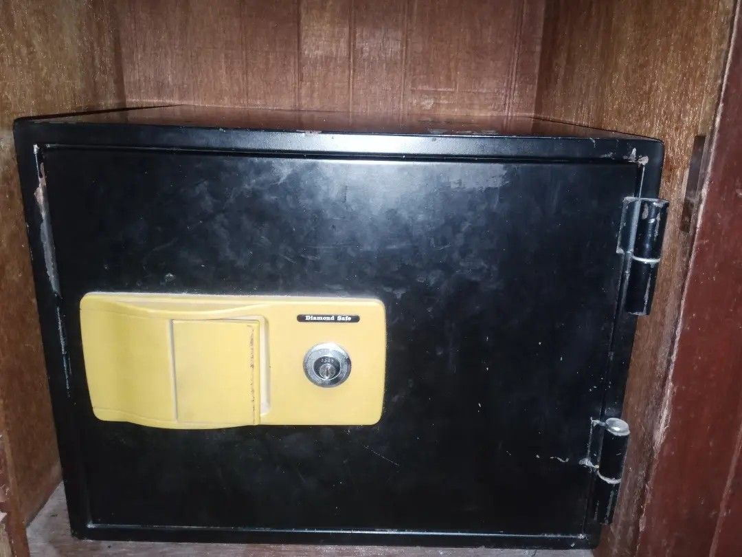 Diamond Safe Heavy Duty Metal Security Box (Category: Safe) located in Santo Tomas. Submitted by solana.xy (Listing ID 1466153055, Image 2). Description: - Brand: Diamond Safe - Material: Heavy-duty metal construction in black - Design: Bright yellow handle and keyhole panel with sturdy right-side external hinges - Security: Standard keyed lock mechanism - Usage: Ideal for storing cash, documents, and valuables - Condition: Minor scuffs from norm