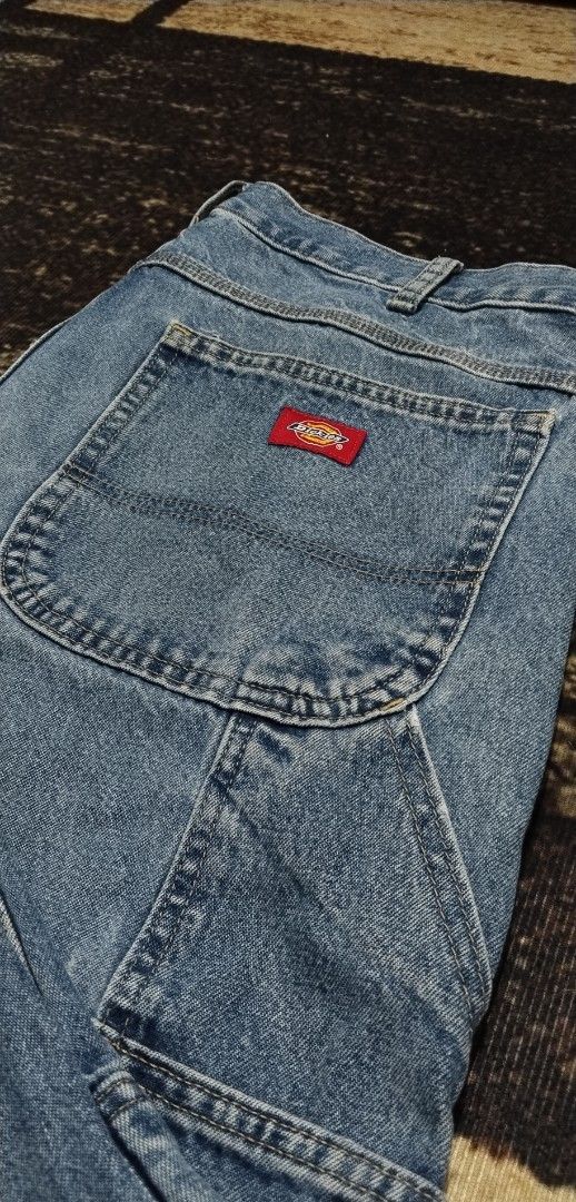 Dickies Light Wash Denim Carpenter Jeans (Category: Jeans) located in Manila. Submitted by ianmontede19006 (Listing ID 1466010667, Image 2). Description: - Brand: Dickies - Style: Denim carpenter jeans with utility pockets and side hammer loops - Color/Wash: Light blue - Fit: Relaxed fit through the leg - Details: Branded metal button closure, iconic red Dickies logo patch on back pocket - Condition: Excellent vintage workwear aesthetic.