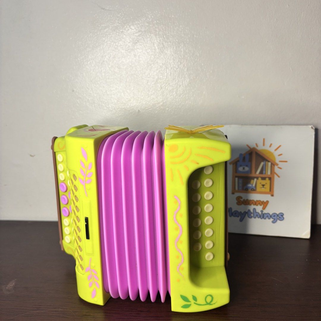 Disney Encanto Mirabel Accordion WORKING (Category: Kids Toys) located in Taguig. Submitted by sunnyplaythingsph (Listing ID 1466086111, Image 1). Description: - Vibrant green and pink kids' accordion - Features a cute butterfly top and decorative leaf side patterns - Equipped with multiple white buttons and working bellows - Great musical toy to help young children explore sounds -Working all buttons, in excellent condition.