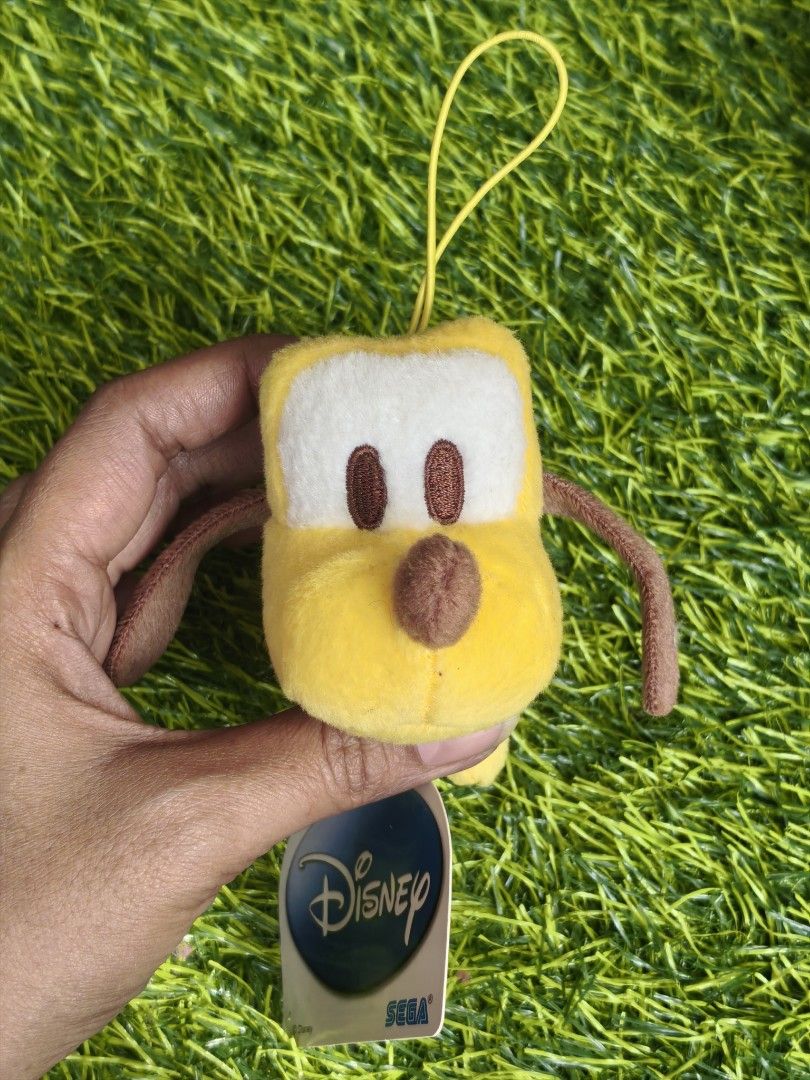 Disney Pluto SEGA Plush Keychain Stuffed Toy (Category: Plushies & Soft Toys) located in Paranaque City. Submitted by furugiyafinds (Listing ID 1466032806, Image 1). Description: - Authentic SEGA Pluto plush keychain - Features iconic yellow body, brown floppy ears, and light green collar - Detailed white patch with brown embroidered eyes - Includes original Disney & SEGA paper tags and Fun Fun Amuse SEGA cloth tag.