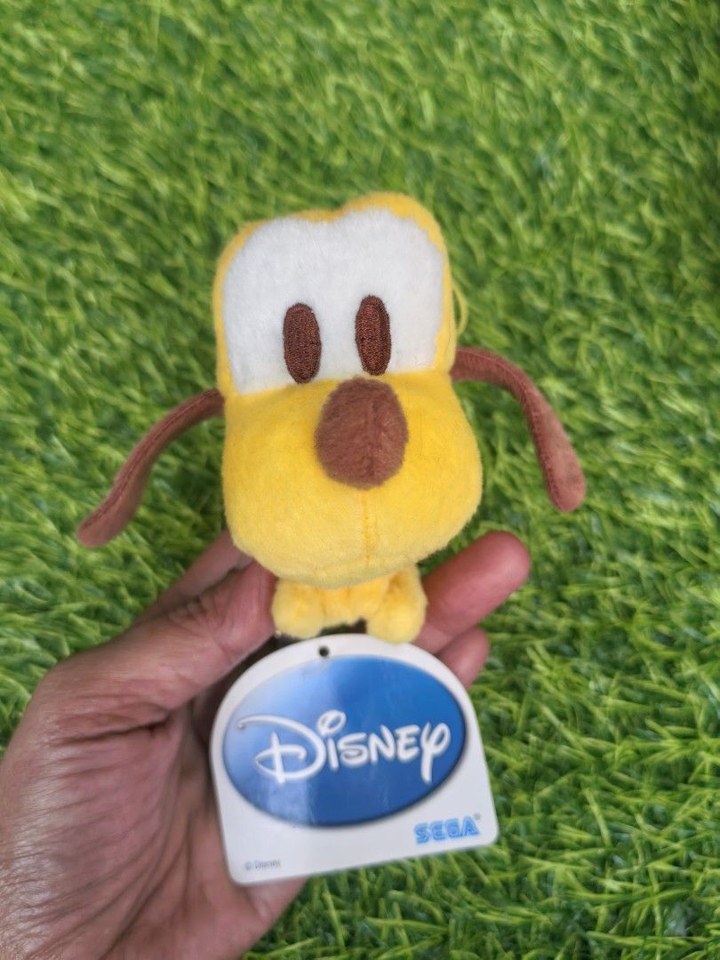 Disney Pluto SEGA Plush Keychain Stuffed Toy (Category: Plushies & Soft Toys) located in Paranaque City. Submitted by furugiyafinds (Listing ID 1466043560, Image 1). Description: - Official SEGA Disney Pluto plush keychain - Features yellow body, brown ears/nose, and green collar - Original Disney tag still attached - Equipped with a yellow string loop for easy hanging - Compact size, ideal for bags or keys.