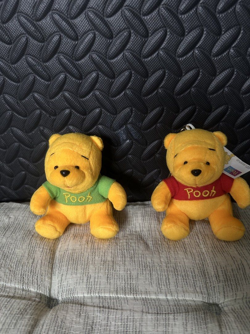 Disney Winnie the Pooh Plush Backpack Keychains Set (Category: Plushies & Soft Toys) located in Cainta. Submitted by shopbyyna (Listing ID 1466010295, Image 1). Description: - Set of 2 official Disney Winnie the Pooh plush backpack keychains - Includes one Pooh in a green top and one in a red top with 'Pooh' embroidered on the front - Features functional zipper compartments on the back and miniature shoulder straps - Brand new with tags (BNWT) at