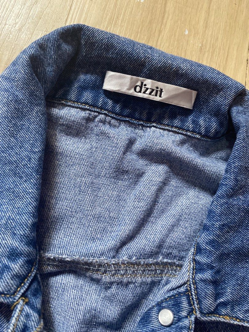 dizzit blue denim jacket (Category: Coats, Jackets and Outerwear) located in Tanauan. Submitted by rie098 (Listing ID 1466040600, Image 3). Description: - Brand: dizzit - Color: Classic blue - Material: Heavy-duty cotton - Closure: Button-up front with metal hardware - Pockets: Two chest flap pockets - Features: Structured collar, versatile layering piece.