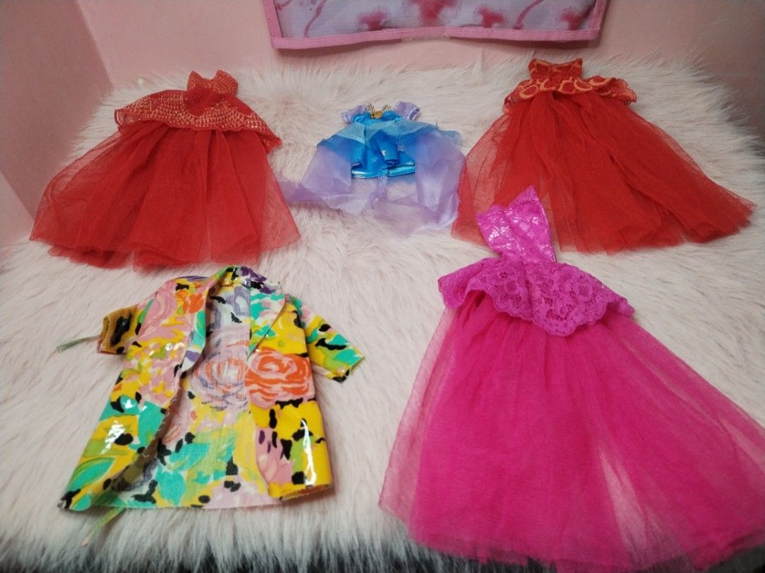 Doll Clothes Set Dresses and Jacket (Category: Kids Toys) located in Paombong. Submitted by eandj.shop (Listing ID 1466047671, Image 2). Description: 🎀 Doll outfit bundle featuring 5 stylish pieces 🎀 Includes: 2 red tulle gowns, 1 bright pink lace and tulle dress, 1 blue dress with a layered sheer cape, and 1 colorful floral jacket with a glossy finish 🎀 Perfect for imaginative dress-up play and expanding your doll's wardrobe.