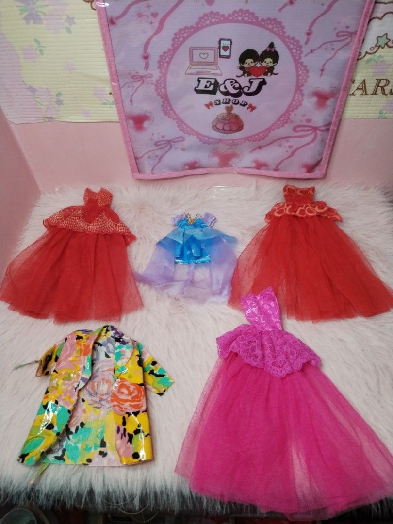 Doll Clothes Set Dresses and Jacket (Category: Kids Toys) located in Paombong. Submitted by eandj.shop (Listing ID 1466047671, Image 1). Description: 🎀 Doll outfit bundle featuring 5 stylish pieces 🎀 Includes: 2 red tulle gowns, 1 bright pink lace and tulle dress, 1 blue dress with a layered sheer cape, and 1 colorful floral jacket with a glossy finish 🎀 Perfect for imaginative dress-up play and expanding your doll's wardrobe.