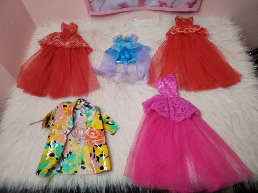 Doll Clothes Set Dresses and Jacket (Category: Kids Toys) located in Paombong. Submitted by eandj.shop (Listing ID 1466047671, Image 3). Description: 🎀 Doll outfit bundle featuring 5 stylish pieces 🎀 Includes: 2 red tulle gowns, 1 bright pink lace and tulle dress, 1 blue dress with a layered sheer cape, and 1 colorful floral jacket with a glossy finish 🎀 Perfect for imaginative dress-up play and expanding your doll's wardrobe.