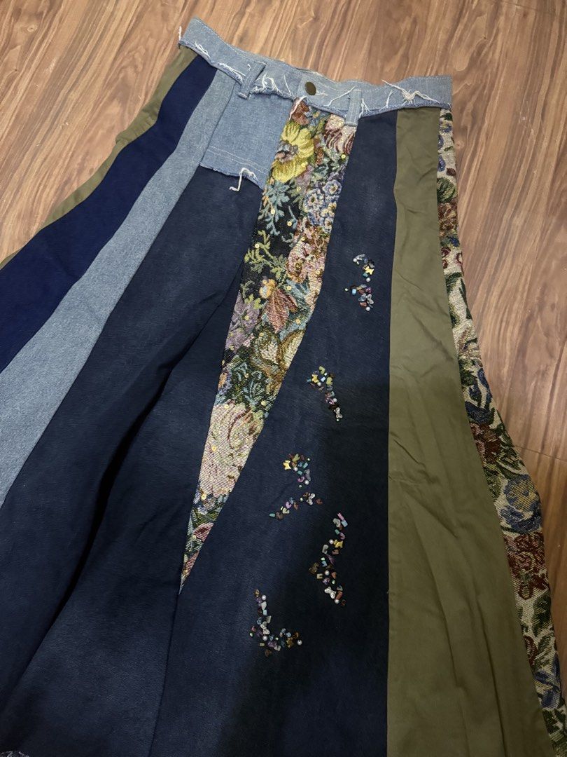 E+ Patchwork Denim and Tapestry Maxi Skirt (Category: Skirts) located in Cebu City. Submitted by hotchkisscebu (Listing ID 1466103501, Image 3). Description: - Brand/Size: E+, Size L - Material: Mixed denim washes, olive green fabric, and ornate floral tapestry panels - Details: Colourful beaded clusters and butterfly charms along a dark denim stripe - Finish: Raw frayed hem at the waistline - Closure: Front button closure - Style: Eye-catching e