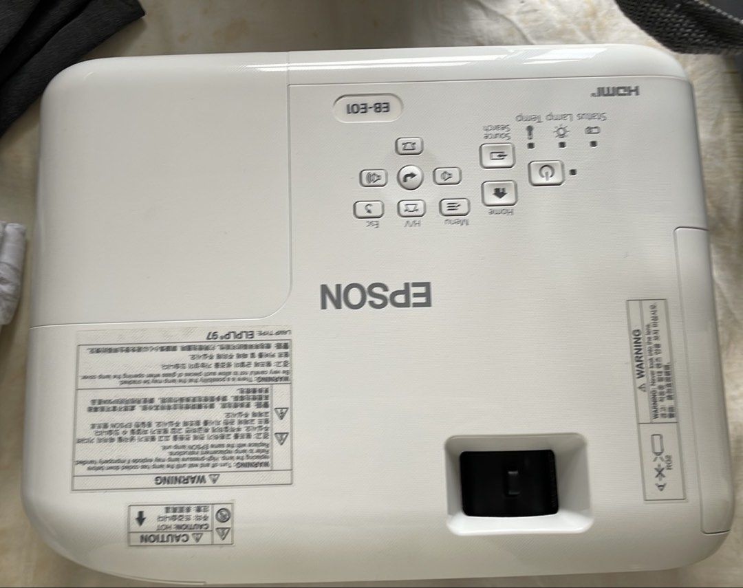 Epson EB-E01 Projector (Category: Projectors) located in Manila. Submitted by little_amy (Listing ID 1466064633, Image 1). Description: - Model: Epson EB-E01 Projector (White housing) - Connectivity: Built-in HDMI port support - Controls: Standard top panel buttons (Power, Home, Menu, Source Search) - Features: Lens focus slider near front corner for easy adjustments - Lamp: Uses ELPLP97 replacement lamp model - Setup: Standard desktop design, pe