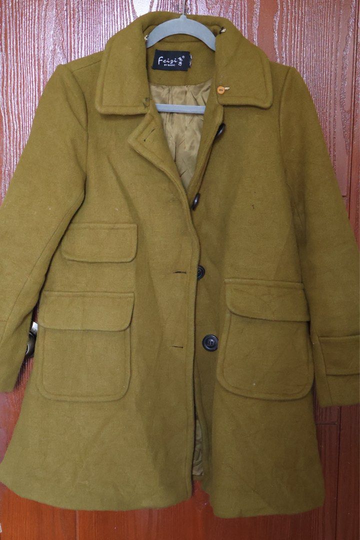 Feizi Olive Green Wool Coat (Category: Coats, Jackets and Outerwear) located in Manila. Submitted by gentlewater-24e8 (Listing ID 1466066345, Image 1). Description: - Brand: Feizi by Basic - Color: Olive Green - Material: Warm wool with fully lined interior - Design: Classic lapel collar with front button closure - Pockets: Multiple front pockets (one small upper pocket and two large lower patch pockets) - Details: Long sleeves with stylish strap