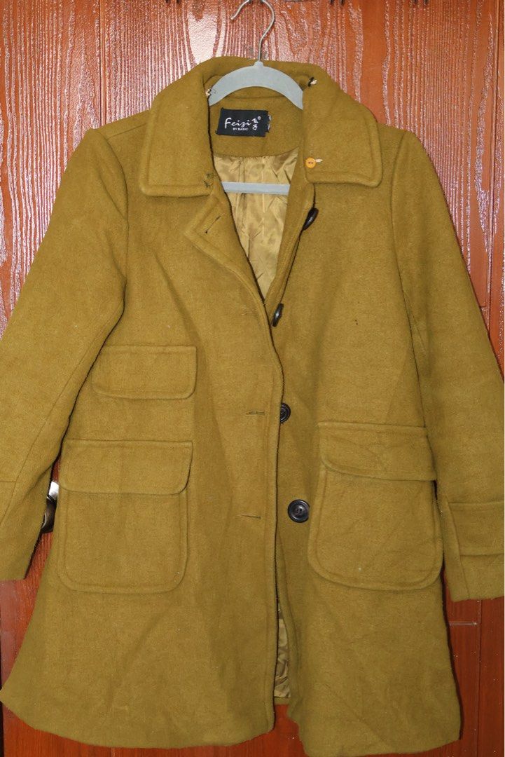 Feizi Olive Green Wool Coat (Category: Coats, Jackets and Outerwear) located in Manila. Submitted by gentlewater-24e8 (Listing ID 1466066345, Image 2). Description: - Brand: Feizi by Basic - Color: Olive Green - Material: Warm wool with fully lined interior - Design: Classic lapel collar with front button closure - Pockets: Multiple front pockets (one small upper pocket and two large lower patch pockets) - Details: Long sleeves with stylish strap